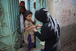 予防接種を受けたしるしを指につける、ボランティアスタッフ（パキスタン）