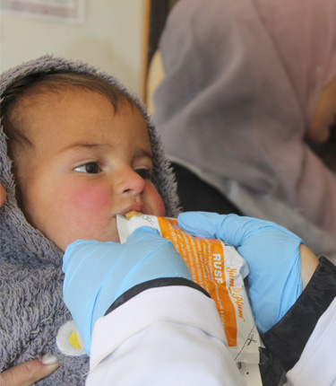 ユニセフが支援する保健施設で栄養補助食品を口にする男の子(2024年12月15日撮影)