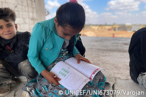 ダエル難民キャンプでユニセフの支援を受ける移動式学習支援のクラスで本を読む女の子