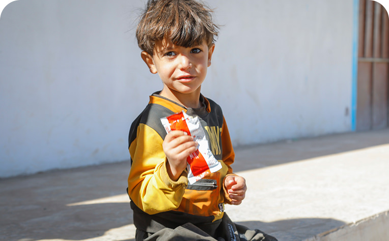 4歳のアダムが治療食を受け取る様子